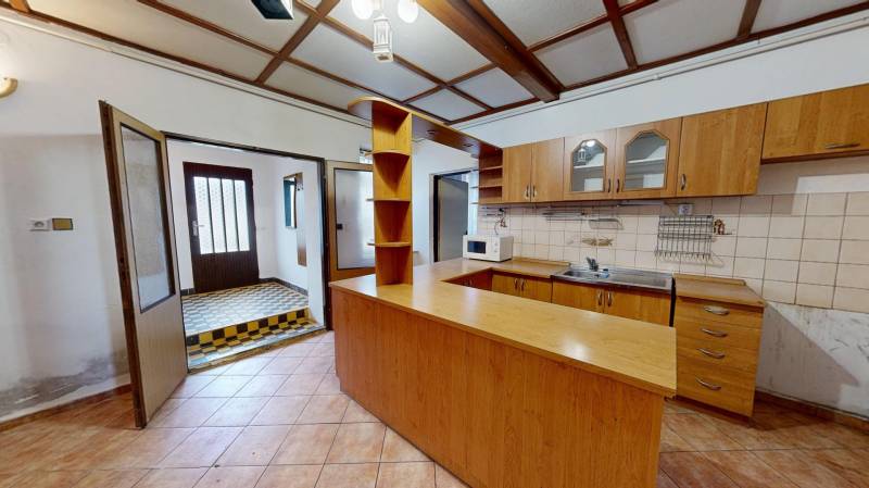A kitchen with wooden decor and tiles in a family house.