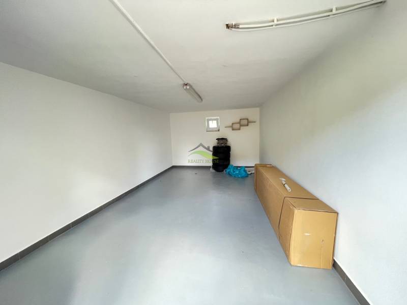 A garage in a family house with white walls and a concrete floor, stored tires.