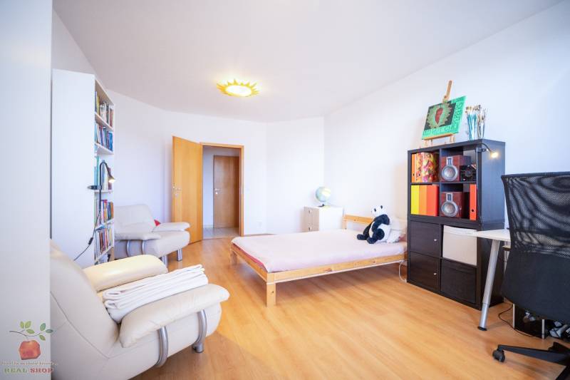 A bright room in a 3-room apartment with a wooden decor floor and cozy furniture.