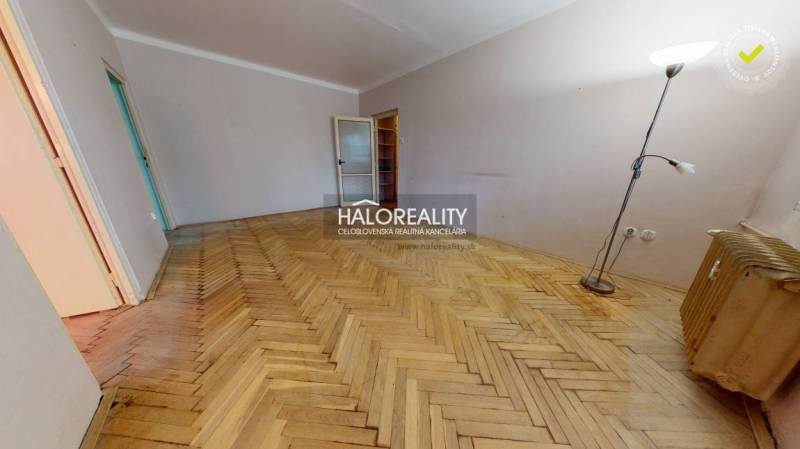 A spacious room with a wooden decor floor in a 3-room apartment, suitable for furnishing.