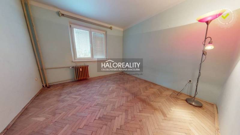 A room in a 3-room apartment with a wooden decor floor and a standing lamp.