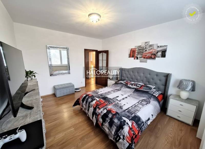 A bedroom in a 3-room apartment with London-themed decorations and a wood-patterned floor.