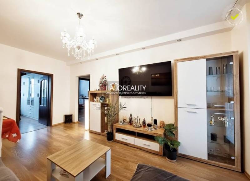 Living room in a 3-room apartment with a wooden decor floor and a crystal chandelier.
