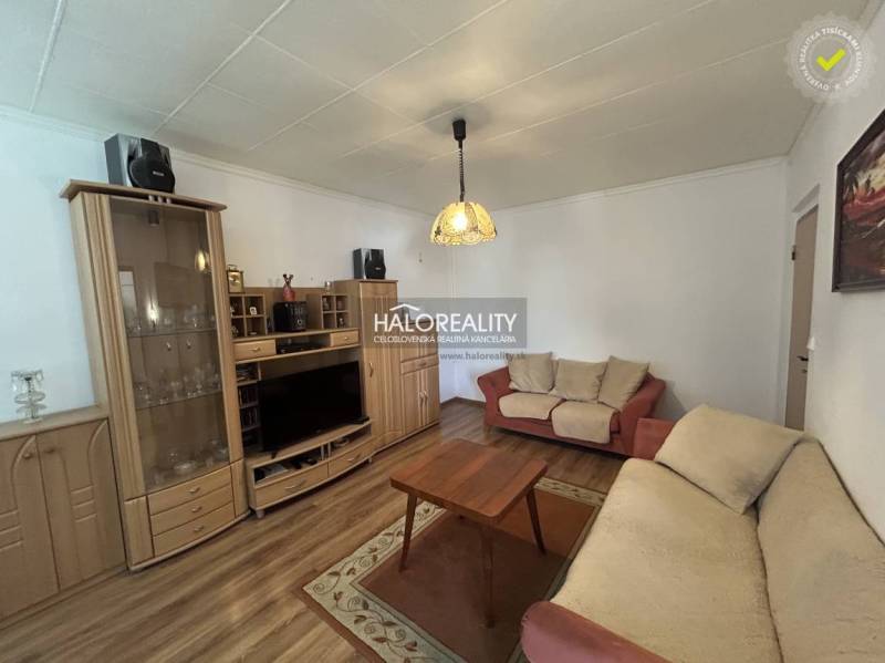 Living room in a two-room apartment with a wooden decor floor and sofas.