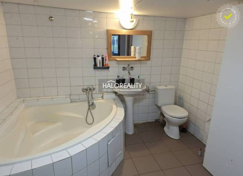 A bathroom in a family house with a bathtub, sink, and toilet. White tiles.