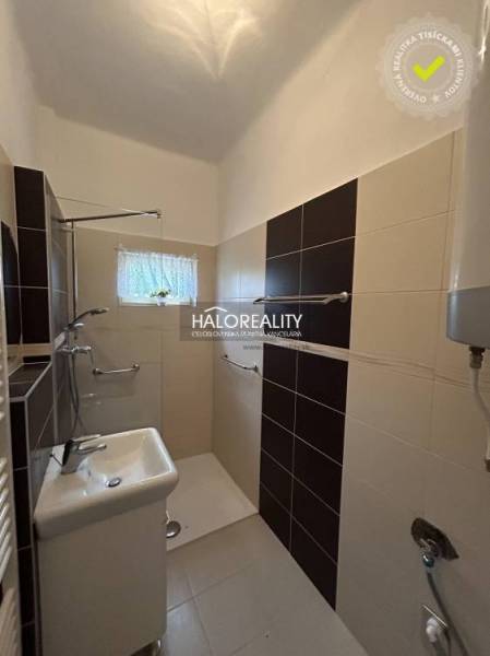 A bathroom in a family house with a shower, a sink, modern tiles, and a window.