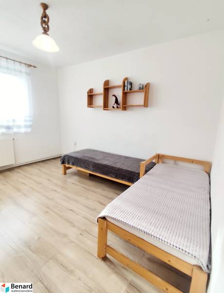 A bright room with two beds in a 3-room apartment, wooden decor flooring.