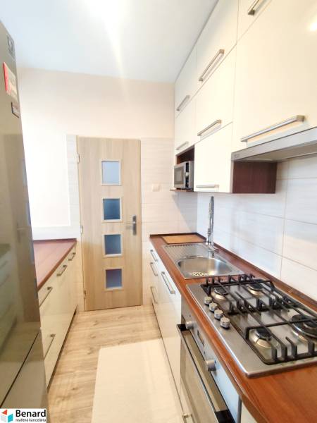 A kitchen in a 3-room apartment with wooden decor countertops and flooring.