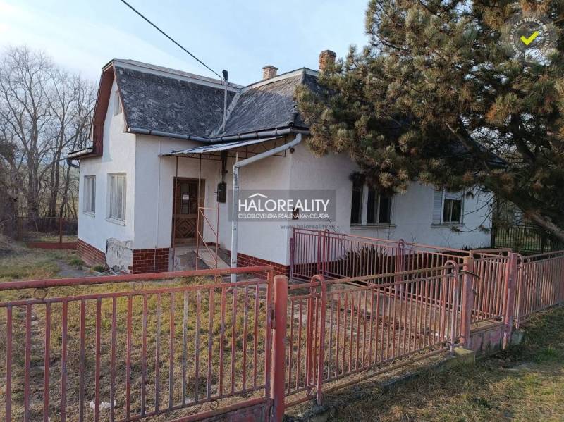 The picture shows an older family house with a front garden and an older fence.