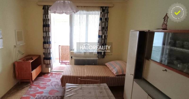 Interior of a room with older furniture and a bed, darkened window, family house.