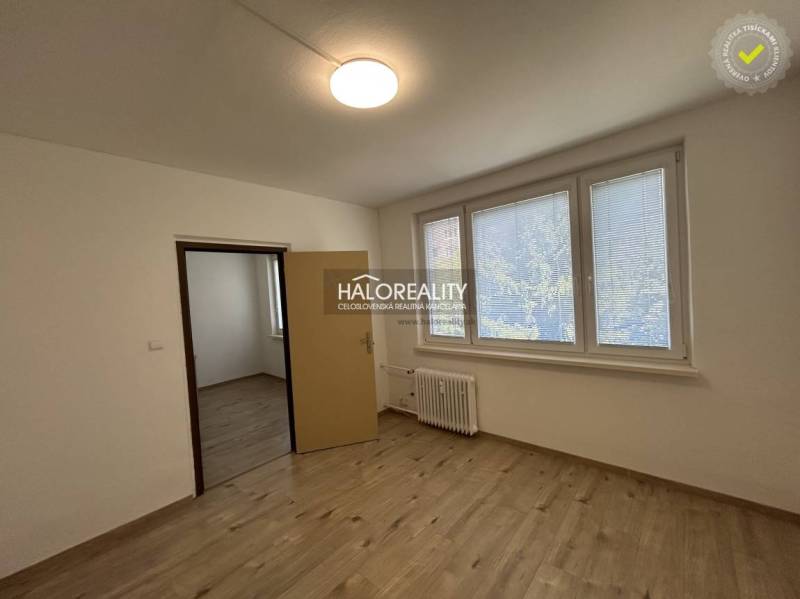 A room in a 3-room apartment with laminate flooring and a large window.