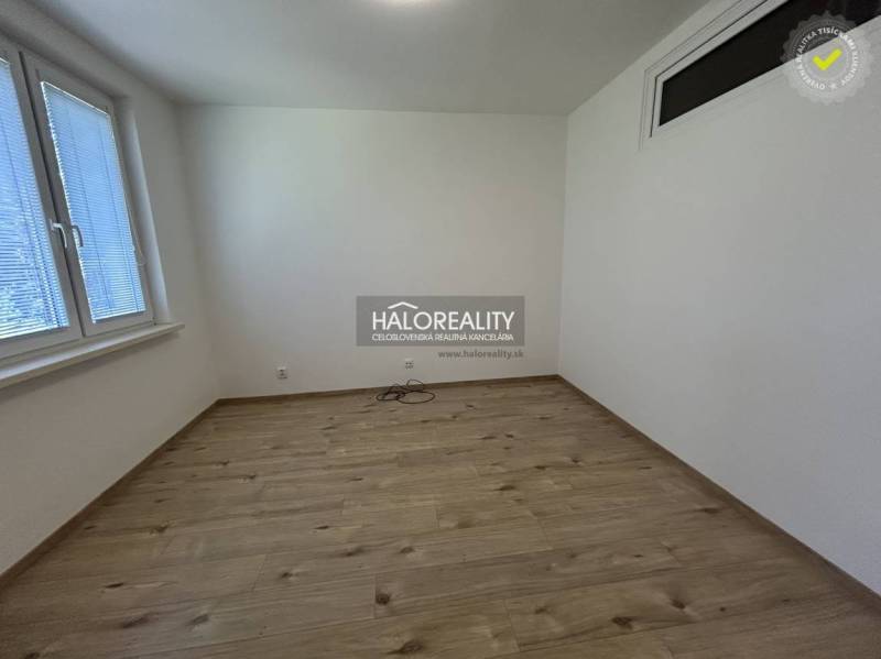 Empty room with wooden floor and two windows in a 3-room apartment.
