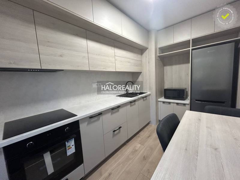 A kitchen in a 3-room apartment with white cabinets and a wood-patterned floor.