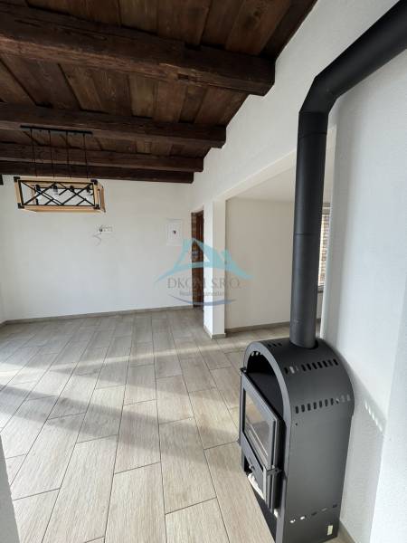 The wooden ceiling, wood-patterned floor, and fireplace in the cabin create a cozy atmosphere.