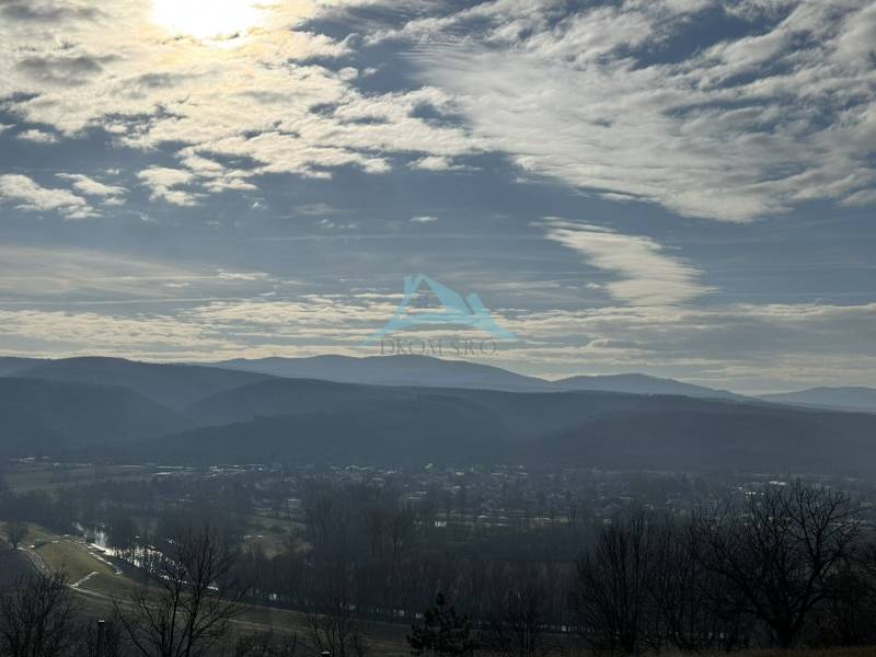Panorama over Šahy with a background of hills and a cloudy sky.