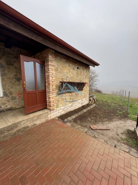 Entrance to the cabin in Šahy with stone cladding and paving.