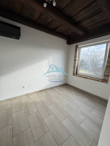 A room with a wooden ceiling, stove, and floor with a wooden decor in a cabin.