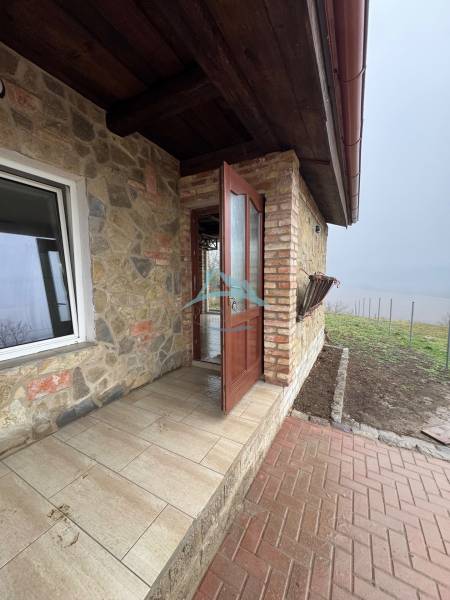 Stone cottage in Šahy with a brick terrace and a view of nature.