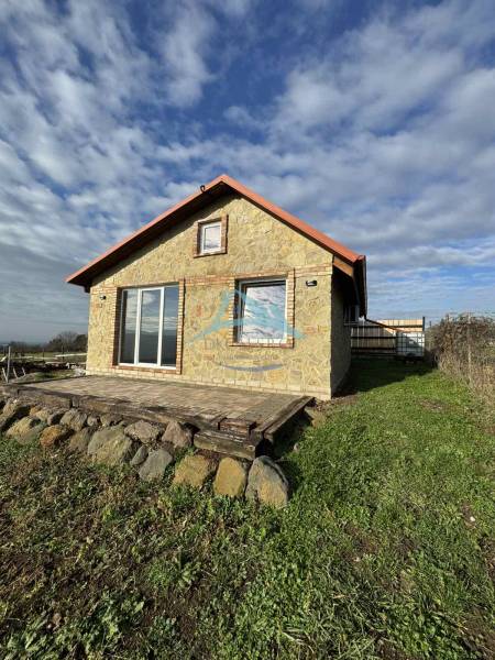 A cottage in Šahy with a stone facade, a terrace, and surroundings with natural stones.