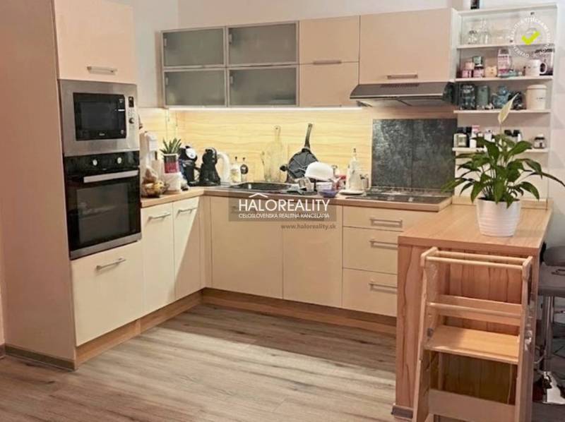Kitchen of a 4-room apartment with a kitchen unit, appliances, and a wooden decor floor.