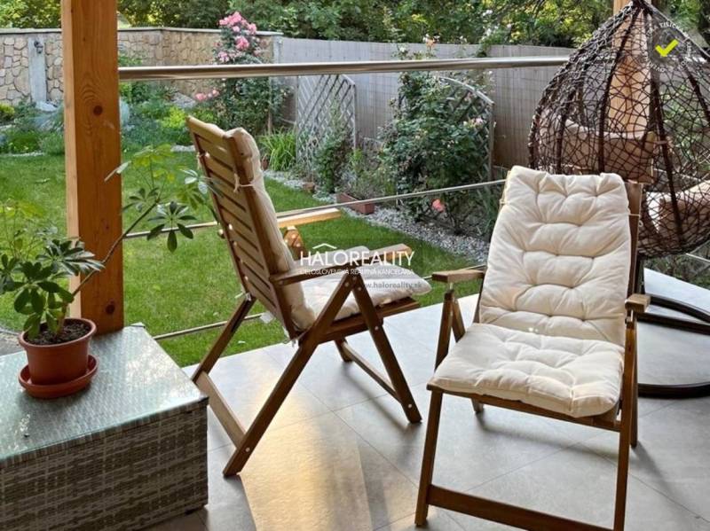 A terrace with garden seating and a green lawn in a 4-room apartment.