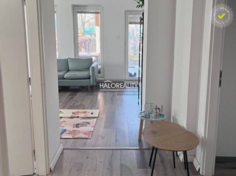 Interior of a 4-room apartment with a wooden decor floor and a sofa.