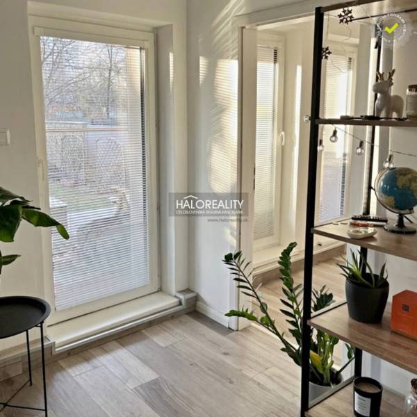 A room with glass doors to the garden and a floor with a wooden decor in a 4-room apartment.