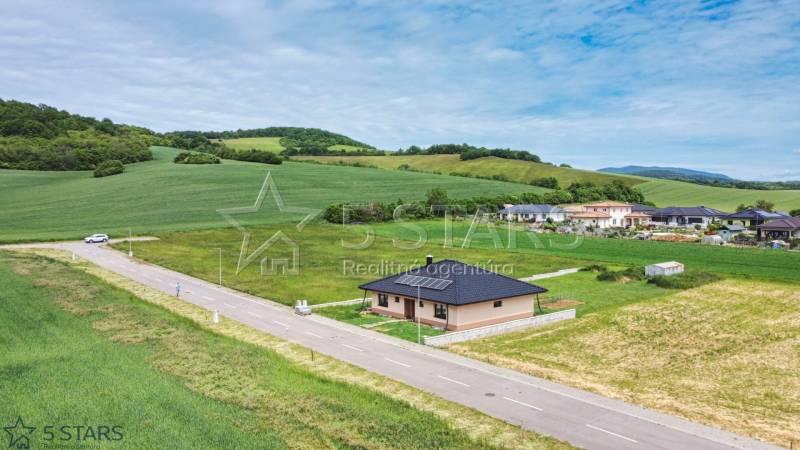 A family house in Štvrtok on Štvrtok Street surrounded by green fields and hills.