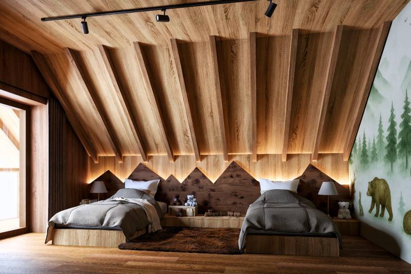 Attic bedroom with two beds, wooden decor, and a forest motif on the wall.