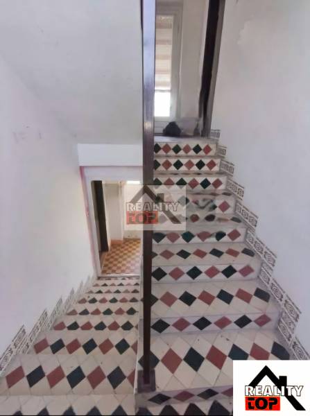 A staircase with colorful tiles in a family house, light and traditional design.