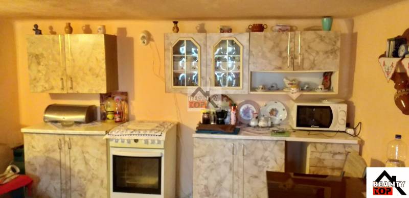 A kitchen in a family house with a kitchen unit and built-in cabinets.
