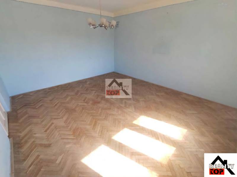 A room in a family house with blue walls and a floor with a wooden decor.