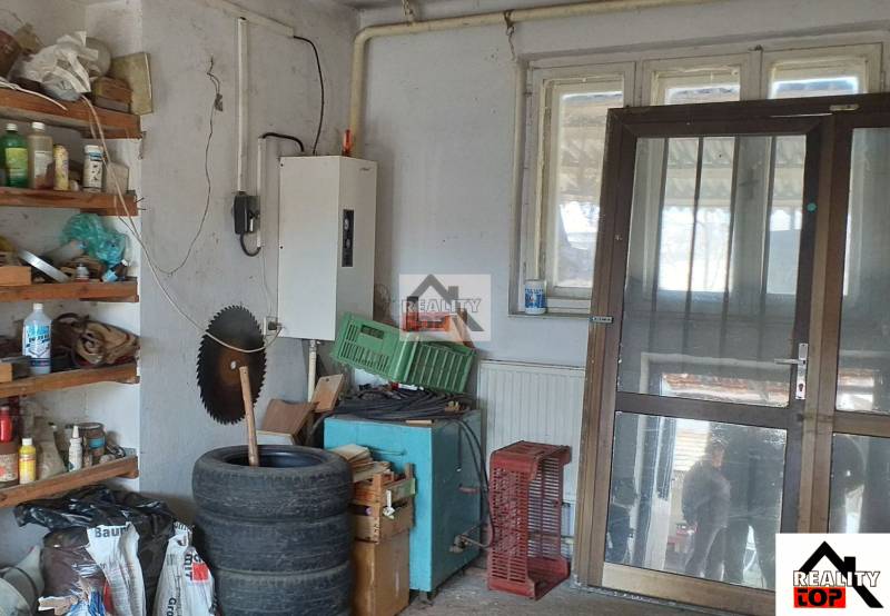 Storage space in a family house with shelves, tires, and electricity.