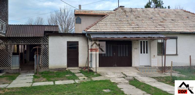 A family house in Studená with a garage, veranda, and traditional roof.