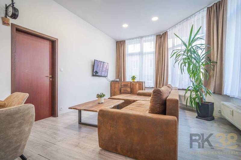 Bright living room, comfortable sofa, large windows, on Hviezdoslavova Street, 4-room apartment.