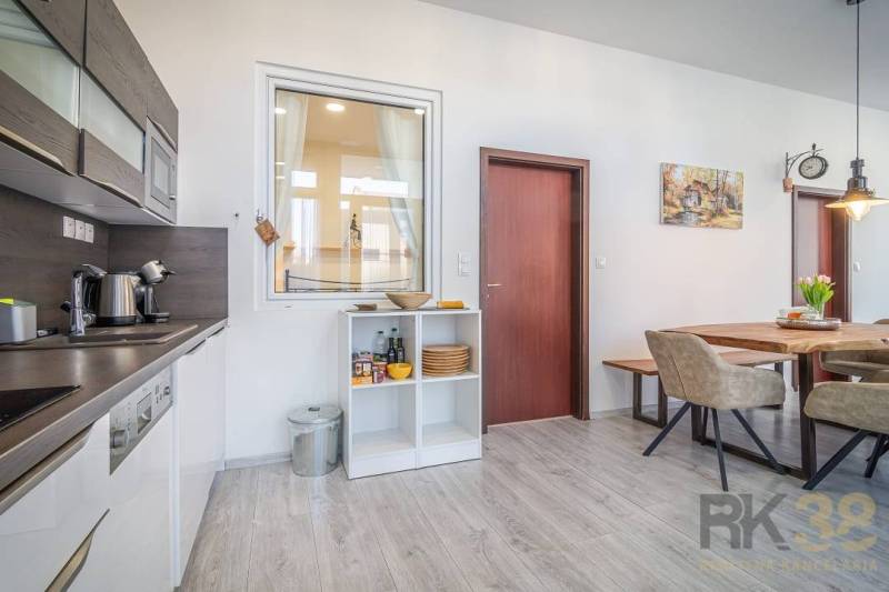 Kitchen and dining room in a 4-room apartment on Hviezdoslavova Street with light furniture and wooden flooring.