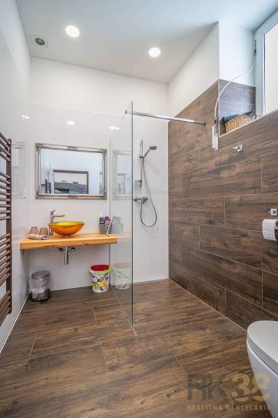 Bathroom with wooden paneling and a modern shower, part of a 4-room apartment on Hviezdoslavova Street.