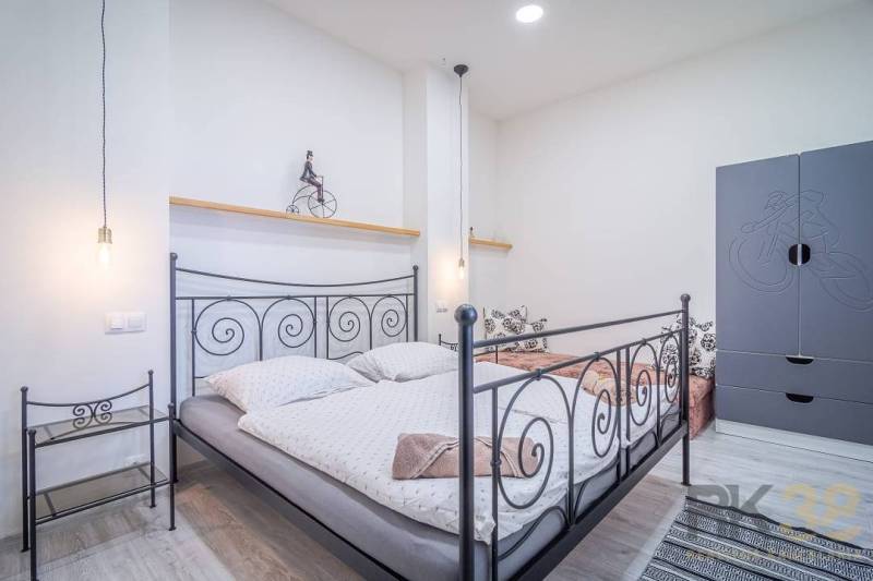 Bedroom with a metal bed and wardrobe in a 4-room apartment on Hviezdoslavova Street.