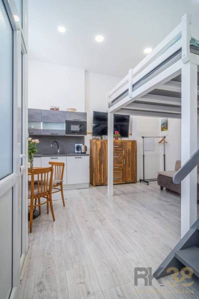 Kitchen and living room with a sofa, bunk bed, wooden furniture on Hviezdoslavova Street.