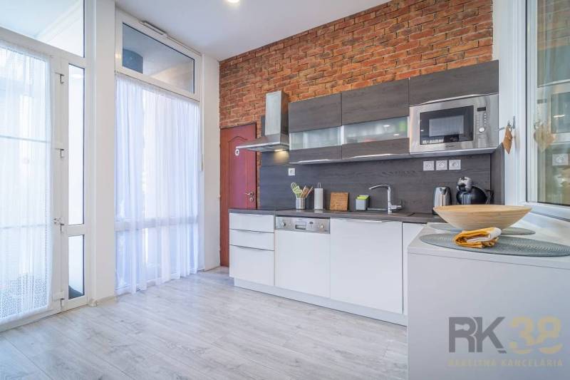 A kitchen in a 4-room apartment with a brick wall, modern appliances, on Hviezdoslavova Street.