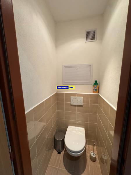 A toilet with tiles and a wall-hung WC in a 2-room apartment.