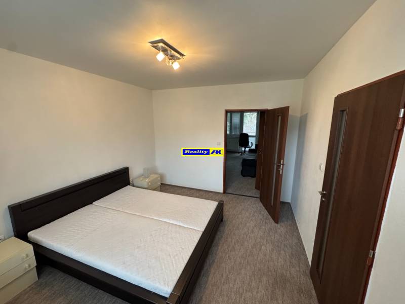 Bedroom in a 2-room apartment with a bed and nightstands, entrance to another room.