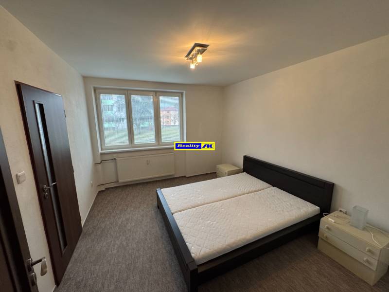 Bedroom in a 2-room apartment with a double bed, two nightstands, carpet.