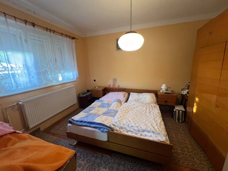 Bedroom in a family house with two beds, a wardrobe, and a carpet.