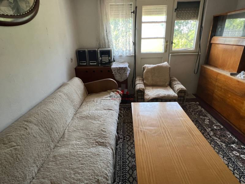 Living room in a family house with a sofa, an armchair, and wooden furniture.