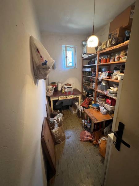 Storage space in a family house with shelves full of various items and an open window.