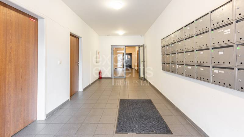 Hallway with mailboxes and tiles in a 2-room apartment.