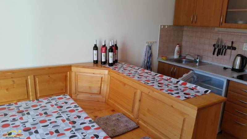 Kitchen in a Holiday Apartment with wooden furniture, table, and kitchen utensils.