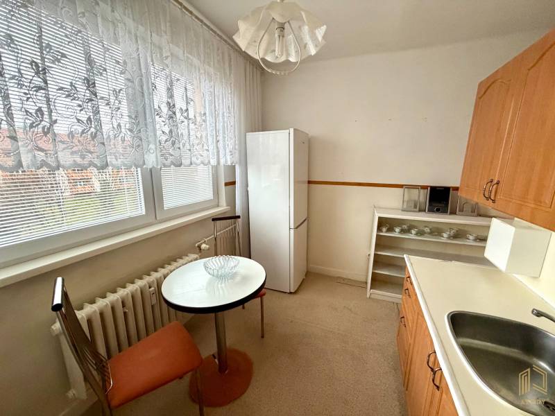 Kitchen in a 3-room apartment with a window, table, and appliances.