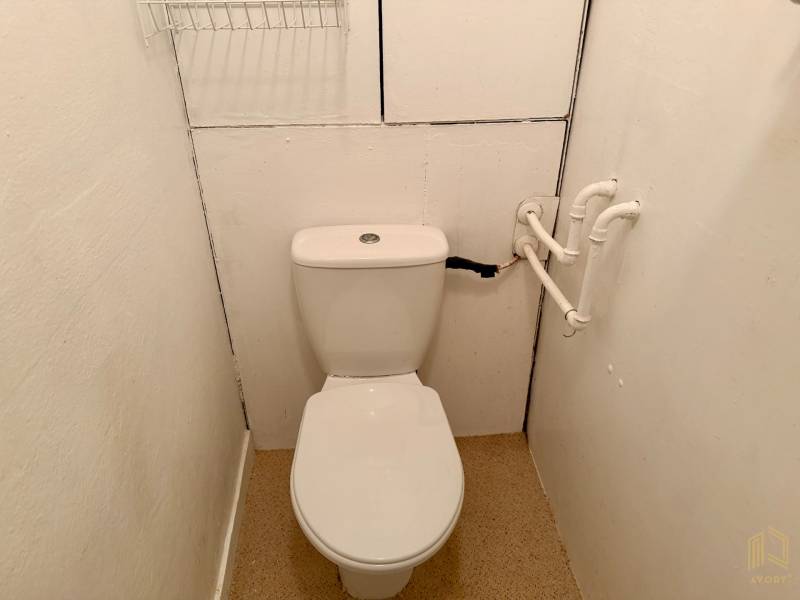 Bathroom in a 3-room apartment with a toilet and white walls.